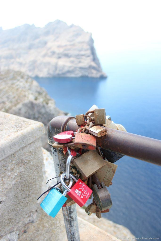 Befestige Liebesschlösser am Geländer auf Cap Formentor auf Mallorc