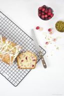 Saftiger Cranberry Pistazien Kastenkuchen mit einer Glasur aus weißer Schokolade obendrauf von Sweets and Lifestyle