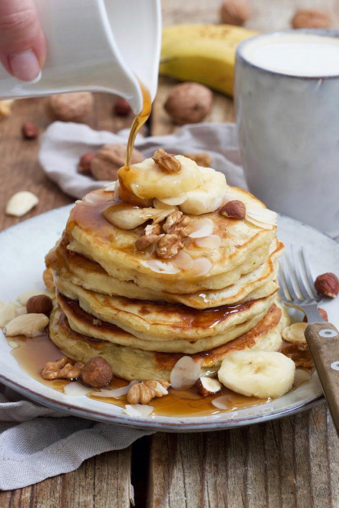 Leckere Bananen Pancakes mit Nüssen und Ahornsirup serviert nach einem Rezept von Sweets & Lifestyle®