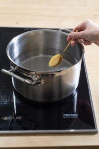 Geformte Griessnockerl in leicht kochendes Wasser geben und fuer 12 Minuten koecheln lassen