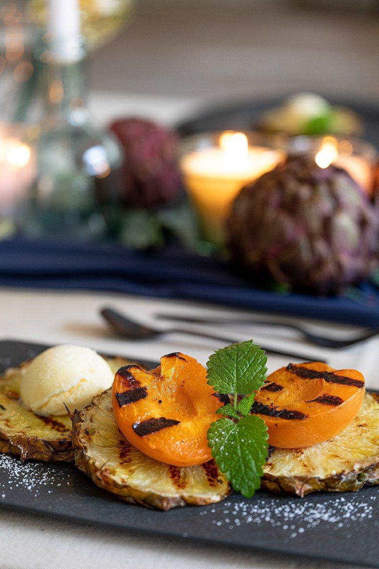 Gegrillte Marille auf gegrillter Ananas serviert mit einer Kugel Vanilleeis als Dessert bei der Grillparty nach einem Rezept von Sweets & Lifestyle®