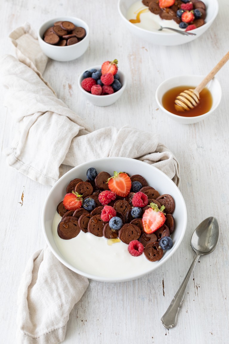 Mini Pfannkuchen so genannte Pancake Cereal mit Kakao serviert mit Joghurt und frischen Fruechten nach einem Rezept von Sweets & Lifestyle®