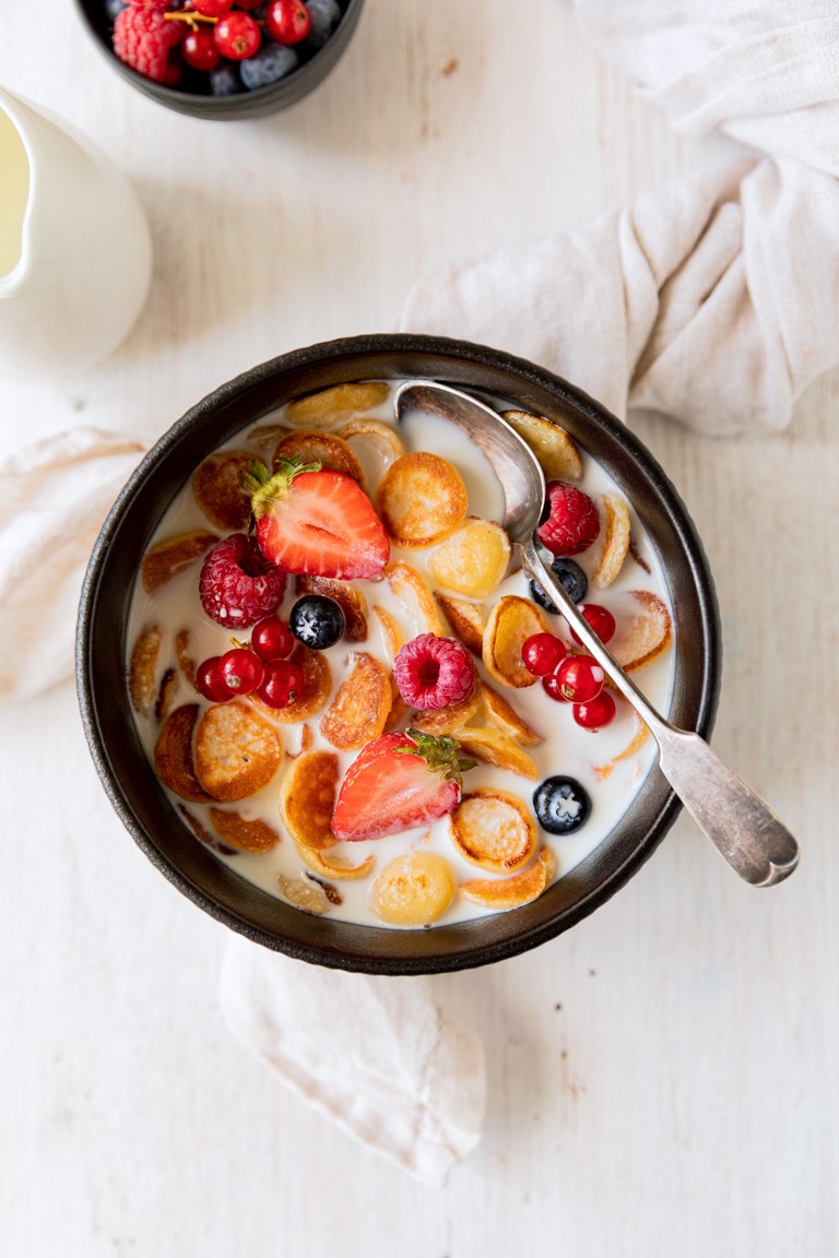 Pancake Cereal mit frischen Beeren und Milch serviert zum Fruehstueck nach einem Rezept von Sweets & Lifestyle®