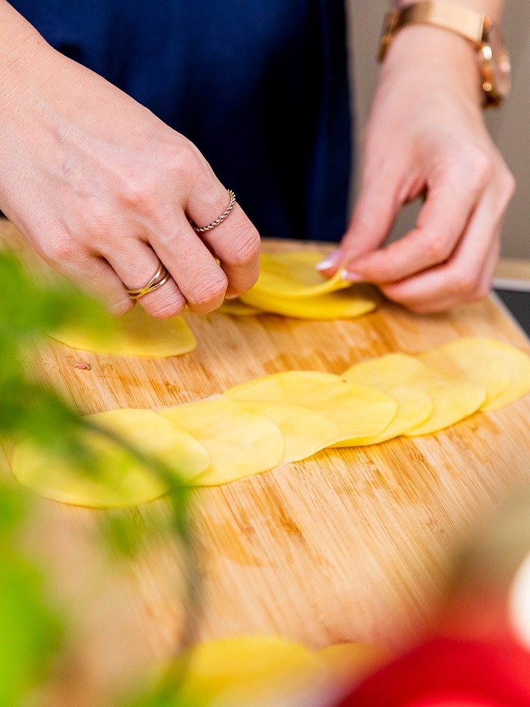 Kartoffelscheiben werden von Foodbloggerin Verena Pelikan ueberlappend aufgelegt um anschließend daraus Kartoffel Roeschen zu formen