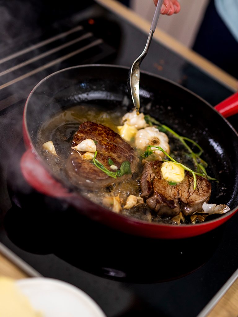Das scharf angebratene Steak wird von Fernsehkoch Alexander Kumptner mit Knoblauch Salbei und Butter in der Pfanne gebraten