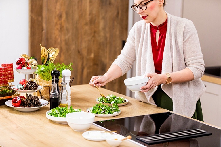 Foodbloggerin und Kochstudio Inhaberin Verena Pelikan beim Anrichten vom winterlichen Vogerlsalat