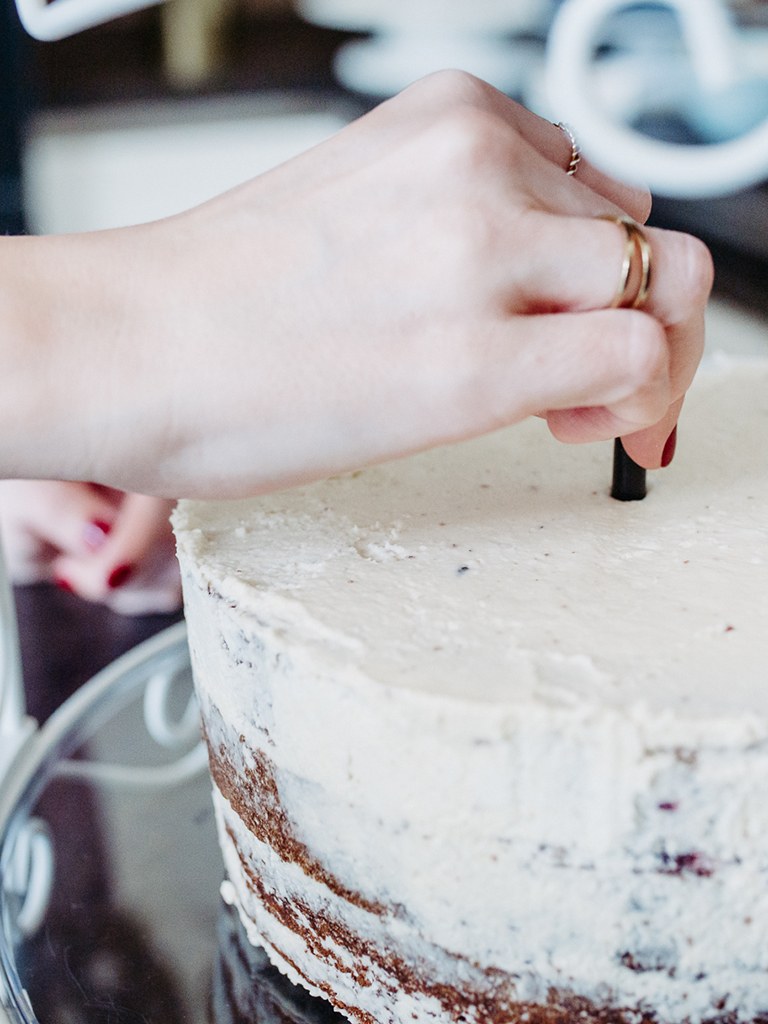 Gekuerzter Strohhalm wird von Foodbloggerin Verena Pelikan in die selbst gemachte Hochzeitstorte gesteckt