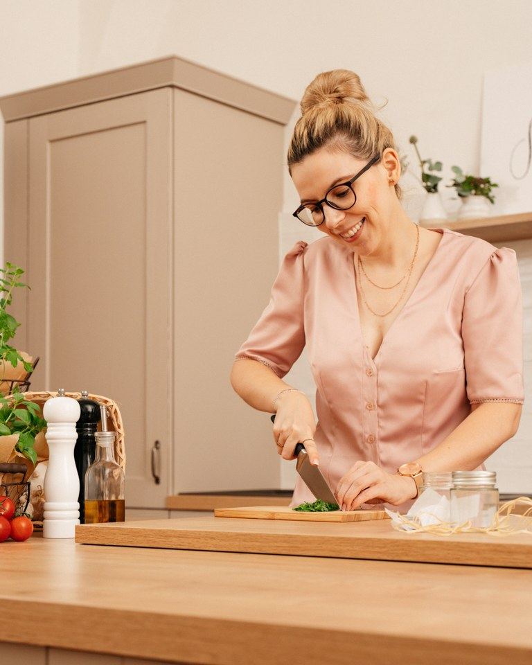 Foodbloggerin Verena Pelikan beim Schneiden der frischen Kraeuter fuer die wuerzige Kraeuterbutter nach ihrem Rezept