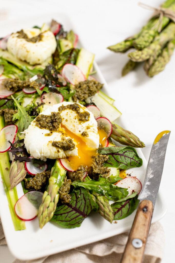 Pochiertes Ei auf gruenem Spargelsalat serviert nach dem Rezept fuer einen Fruehlingssalat mit Spargel von Foodbloggerin Verena Pelikan