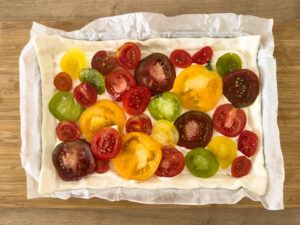 Bunte Tomatenstuecke auf den Blaetterteig legen