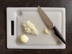 Zwiebel und Knoblauch fein hacken fuer die Lachssauce