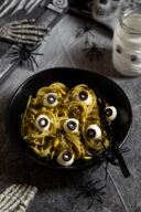Gruene Monster Spaghetti mit Augen aus Mozzarella und Oliven fuer die Party zu Halloween